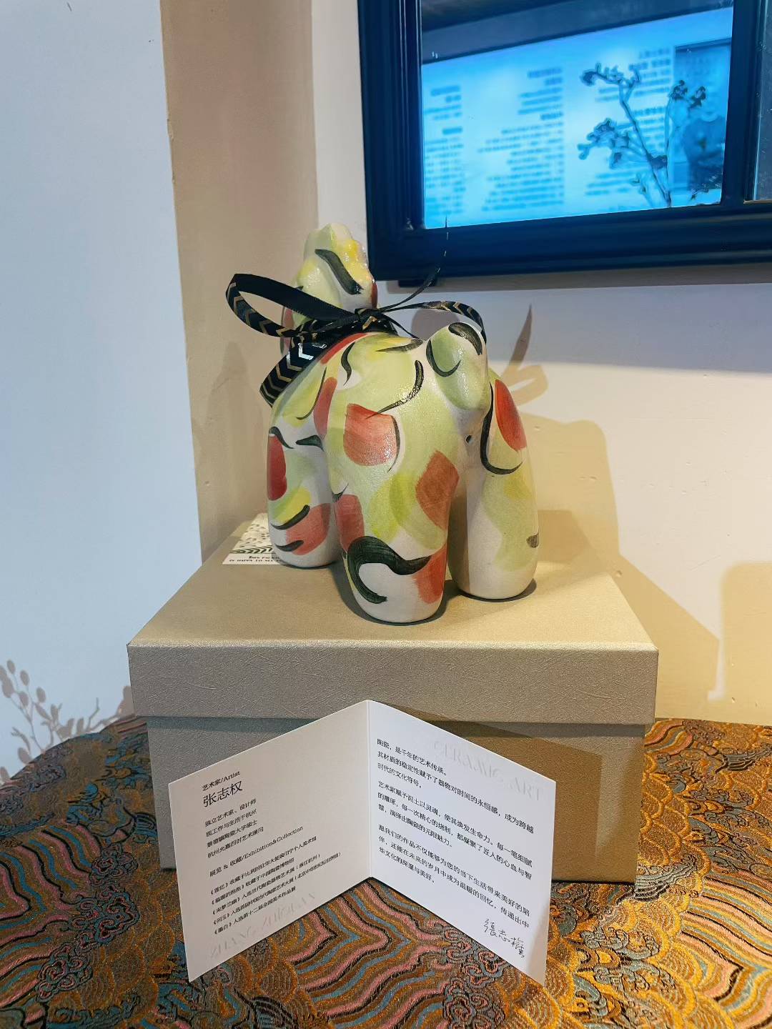 Porcelain Unicorn-Apple Green figure with colorful abstract pattern and black ribbon on beige box